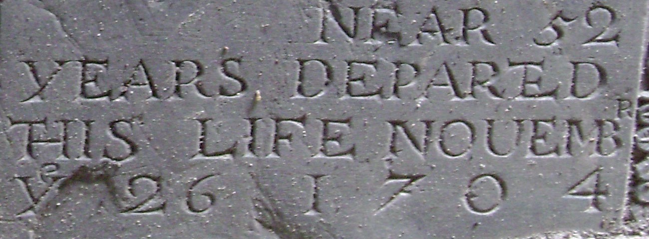 Slate gravestone in carved capitals: near 52 years departed this life Nouembr ye 26 1704